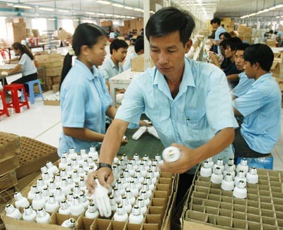 Workers produce energy-saving light bulbs at Dien Quang Company (Photo: SGGP)